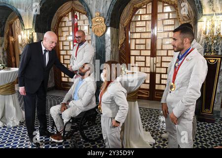 Der tunesische Präsident Kais Saied ehrt den Meister Rawaa Tlili, der bei den Paralympischen Spielen in Paris 2024 eine Goldmedaille im Kugelstoßen und eine Goldmedaille im Diskuswurf gewann, sowie den Champion Walid Ktila, der im 100-m-Rollstuhl eine Silbermedaille gewann. Der tunesische Präsident von Karthago, Kais Saied, ehrt den Meister Rawaa Tlili, der bei den Paralympischen Spielen in Paris 2024 eine Goldmedaille im Kugelstoßen und eine Goldmedaille im Diskuswurf gewann, und ehrt auch den Champion Walid Ktila, der im 100-m-Rollstuhl eine Silbermedaille gewann. Carthage Palace, Tunis, am 11. September 2024. Foto: Tunesischer Ratsvorsitz apaimages Tunis Tunis Tu Stockfoto