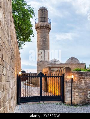 Das Minarett der Schah-Moschee erhebt sich vor Sonnenuntergang über den umliegenden Gebäuden in Baku, Aserbaidschan Stockfoto