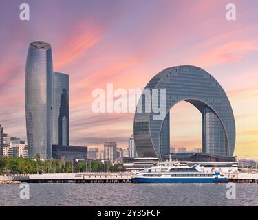 Das atemberaubende Crescent Development Project bietet eine unverwechselbare Architektur entlang der Küste des Kaspischen Meeres von Baku in Aserbaidschan, die von einem lebhaften Sonnenuntergang beleuchtet wird, der den Reiz der Skyline unterstreicht Stockfoto
