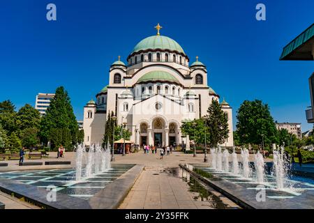 Belgrad, Serbien - 29. April 2024: Saint-Sava-Tempel in Belgrad, Serbien, mit einem klaren blauen Himmel und üppigem Grün rund um die berühmte weiße Kirche. Stockfoto