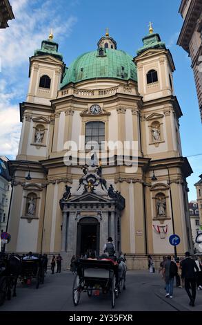 Eine Pferdekutsche fährt an der historischen Peterskirche in Wien vorbei. Stockfoto