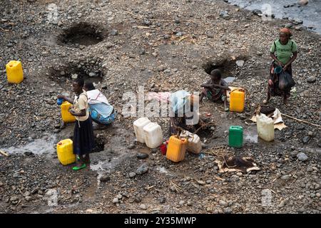 Frauen sammeln Wasser mit Plastikkannen an Wasserlöchern am Ufer eines Flusses, in der Nähe der Straße von Arba Minch nach Konso im Süden Äthiopiens Stockfoto