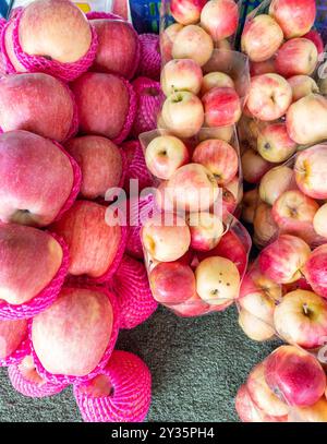 Nahaufnahme des frischen Apfels in der Plastiktüte und der Einwegstoßstange, angeordnet auf einem Obststand auf dem lokalen Markt, Vorderansicht mit dem Kopierraum. Stockfoto