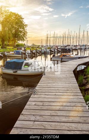 Boote am Pier von Langballigau während des wunderschönen Sonnenuntergangs an der Ostsee in Norddeutschland Stockfoto