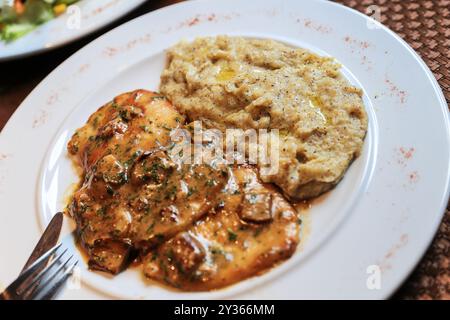 Spezialitäten der Schweizer Küche Tessin und Bündner - Polenta Rosso mit Fleischstücken und Pilzen. Polenta rosso ist eine Rote Maisart, die in Th wächst Stockfoto