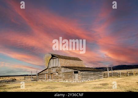 Sonnenuntergang über dem Mormon Row Historic District im Teton Range des Grand Teton National Park im US-Bundesstaat Wyoming Stockfoto