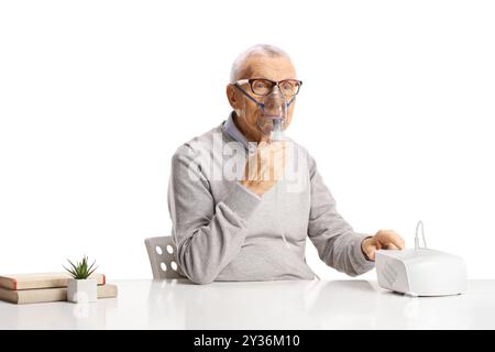 Senior sitzend und mit einem Vernebler isoliert auf weißem Hintergrund Stockfoto