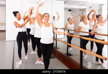 Verschiedene ältere Frauen trainieren Ballettbewegungen mit Trainer Stockfoto