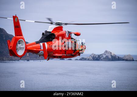 Ein Helikopter der Küstenwache San Francisco MH-65 Dolphin führt in Pacifica, Kalifornien, am 10. September 2024 eine Evolution zum Heben von Klippen durch. Klippenrettung Stockfoto