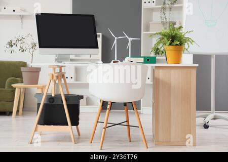 Techniker-Arbeitsplatz mit Computermonitoren, Anlagen- und Windkraftanlagenmodellen im Büro Stockfoto