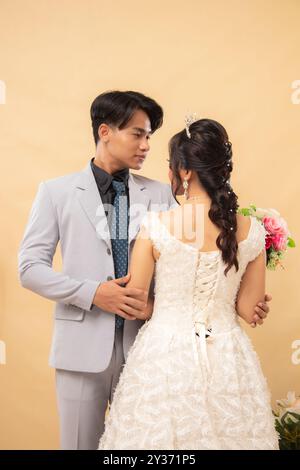 Elegantes männliches und weibliches Paar stehend posiert entspannt lächelnd leicht nach vorne schauend männliche Hände halten liebevoll Arme innen Foto nah Stockfoto