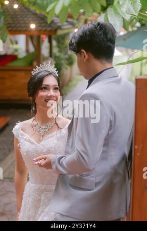 Ein Paar Mann und Frau elegant posiert gegenüber der Frau und sieht einen lächelnden Mann in wunderschönem Kleid bei einem Park-Foto-Shooting an. National Bride Outdo Stockfoto