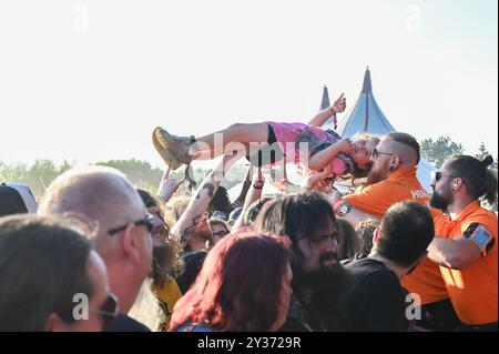 Sicherheitskräfte tragen einen jungen Crowdsurfer sicher über die Menge während des Bloodstock Open Air Heavy Metal Festivals in Catton Hall am 11. August 2024 [Credit Graham Finney] mit: Atmosphäre Where: Walton on Thames, Vereinigtes Königreich Wann: 11 Aug 2024 Credit: Graham Finney/WENN Stockfoto