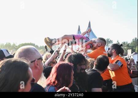 Sicherheitskräfte tragen einen jungen Crowdsurfer sicher über die Menge während des Bloodstock Open Air Heavy Metal Festivals in Catton Hall am 11. August 2024 [Credit Graham Finney] mit: Atmosphäre Where: Walton on Thames, Vereinigtes Königreich Wann: 11 Aug 2024 Credit: Graham Finney/WENN Stockfoto