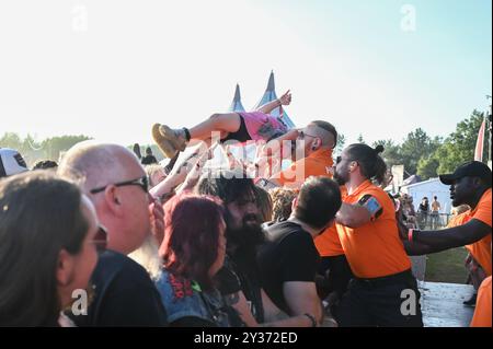 Sicherheitskräfte tragen einen jungen Crowdsurfer sicher über die Menge während des Bloodstock Open Air Heavy Metal Festivals in Catton Hall am 11. August 2024 [Credit Graham Finney] mit: Atmosphäre Where: Walton on Thames, Vereinigtes Königreich Wann: 11 Aug 2024 Credit: Graham Finney/WENN Stockfoto