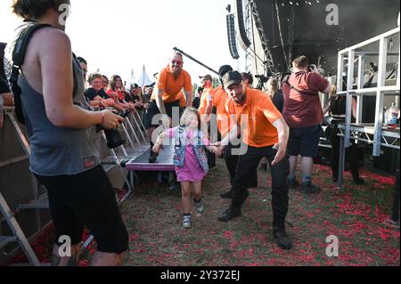 Sicherheitskräfte tragen einen jungen Crowdsurfer sicher über die Menge während des Bloodstock Open Air Heavy Metal Festivals in Catton Hall am 11. August 2024 [Credit Graham Finney] mit: Atmosphäre Where: Walton on Thames, Vereinigtes Königreich Wann: 11 Aug 2024 Credit: Graham Finney/WENN Stockfoto