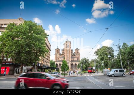 BELGRAD, SERBIEN - 23. JULI 2024: Kirche des Heiligen Markus, auch Crkva Svetog Marka genannt, in der Abenddämmerung vor Autos, die in Geschwindigkeitsunschärfe vorbeifahren. Es ist eine Orth Stockfoto