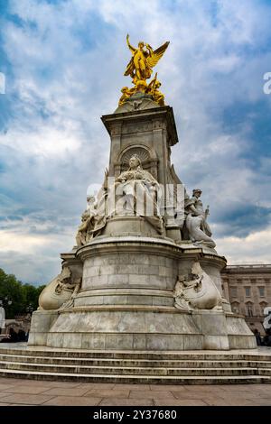 London, England - 17.05.2024: Die Victoria Memorial Statue befindet sich außerhalb von Buckingham mit Autos, die umherfahren. Das Marmordenkmal ist oben auf wi Stockfoto
