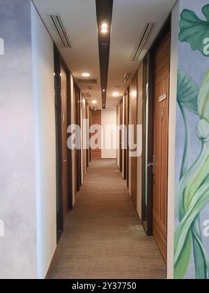 Leerer schmaler Büroflur mit warmem Licht, Büroinnenraum. Stockfoto