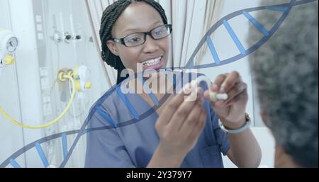 Bild des dna-Strangs über afroamerikanischer Ärztin, die ein Hörgerät für Senioren anpasst Stockfoto