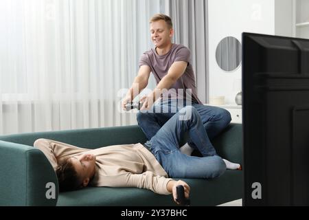 Junge Brüder, die zu Hause auf dem Sofa Videospiele spielen Stockfoto