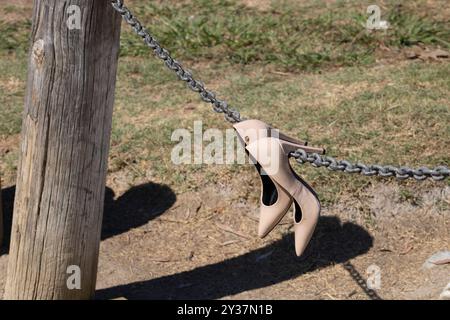 Beige Absätze hängen an einem Kettenseil auf einer Brücke Stockfoto