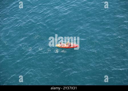 Blaues Meerwasser, rotes gelbes Boot mit Rudern, zwei Personen Sport Hintergrund Dubrovnik, Kroatien 22. April 2023. Hochwertige Fotos Stockfoto