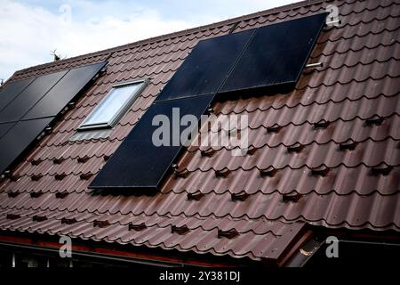 Auf einem Dach installierte Photovoltaik-Solarpaneele, die saubere Energie für eine nachhaltige Zukunft erzeugen. Stockfoto