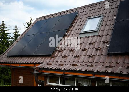 Auf einem Dach installierte Photovoltaik-Solarpaneele, die saubere Energie für eine nachhaltige Zukunft erzeugen. Stockfoto