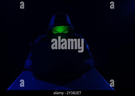 Cyber-Hacker, Digital Cybersecurity Concept mit Hooded Hacker und Computerschnittstelle auf dunklem Hintergrund, anonymer Spion. Stockfoto