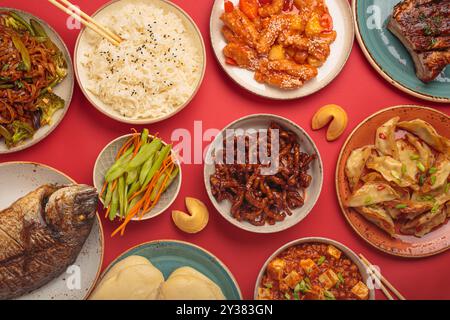 Verschiedene traditionelle chinesische Gerichte von oben auf rotem Hintergrund: kung PAL Huhn, süß-saures Schweinefleisch, Nudeln, Knödel, mapo Tofu, Fisch, Reis Stockfoto