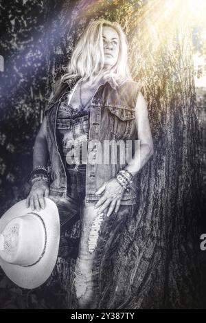 Ein Schwarzweiß-Foto, das eine Frau zeigt, die einen Cowboyhut hält Stockfoto