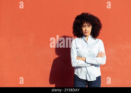 Unternehmerin, die mit überkreuzten Armen steht Stockfoto