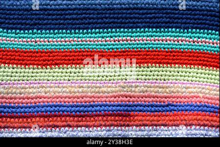Gestrickte und farbige Streifen handgefertigter Teppich. Gemütlicher Hintergrund Stockfoto