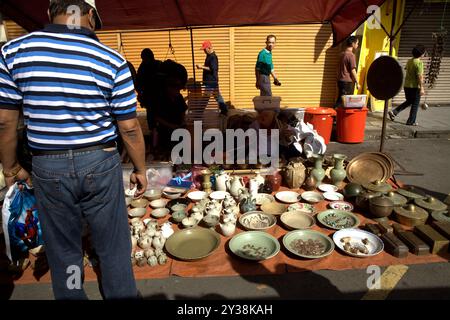 Ein Mann, der beim Gaya Sunday Market in der Gaya Street, Kota Kinabalu, Sabah, Malaysia, auf Porzellan achtet. Stockfoto