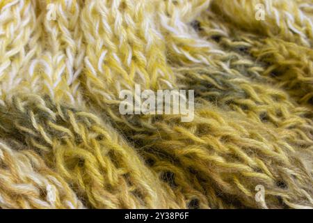 Verlaufender gestrickter Hintergrund. Zitronenfarbene Alpaka- und Wollfäden mit wunderschönem Strickmuster. Verlaufende Häkelarbeit in warmen Farben. Strickhobbyarbeit. Stockfoto