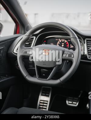 Innenraum von Leon Cupra. Nahaufnahme des Lenkrads und des Armaturenbretts einer sportlichen Heckklappe in einer Stadt. Stockfoto