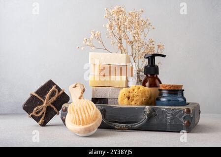 Ein wunderschön gestaltetes Badezimmerset mit handgefertigten Seifen, einer Holzbürste und einem natürlichen Schwamm. Ideal für natürliche Hautpflege, Wellness-Routinen Stockfoto