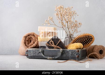 Ein wunderschön gestaltetes Badezimmerset mit handgefertigten Seifen, einer Holzhaarbürste und einem natürlichen Schwamm. Ideal für natürliche Hautpflege, Wellness-Routinen, Stockfoto