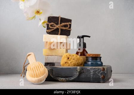 Ein wunderschön gestaltetes Badezimmerset mit handgefertigten Seifen, einer Holzbürste und einem natürlichen Schwamm. Ideal für natürliche Hautpflege, Wellness-Routinen Stockfoto