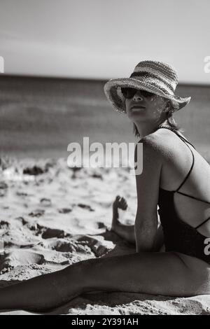 Eine Frau im Badeanzug ruht am Strand. Stockfoto