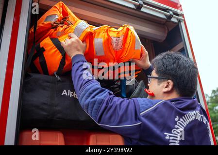 Chiang Mai, Thailand. September 2024. Ein Rettungsbeamter aus der Gemeinde Chiang Mai lädt Rettungswesten in das Rettungsfahrzeug, bevor er aufbricht, um den Überschwemmungsopfern im Bezirk Mae Ai, Chiang Mai, Thailand, zu helfen. Um das Hochwasserproblem im Bezirk Mae ai anzugehen, hat die Stadtverwaltung Chiang Mai Personal und Ausrüstung eingesetzt, darunter Rettungsfahrzeuge, Flachbodenboote, Wassertankschiffe, Kräne, Bagger, LKWs und Krankenwagen, um den Hochwasseropfern zu helfen. Die Operation dauert voraussichtlich etwa 5 Tage. Quelle: SOPA Images Limited/Alamy Live News Stockfoto