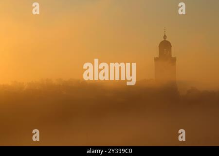 Der Turm der Großen Kirche in der Stadt Deventer, Niederlande, über dem Nebel an einem kalten Herbsttag Stockfoto