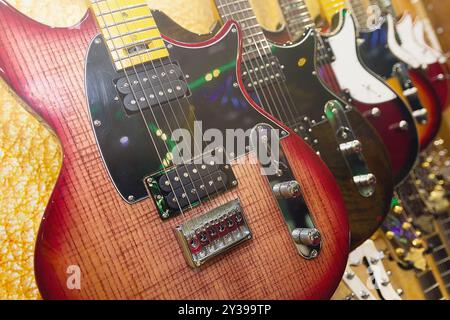 Eine Reihe verschiedener E-Gitarren hängen in der Nähe des Musikgeschäfts Stockfoto