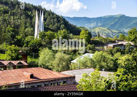 Stadtbild der Stadt Dilijan, Armenien mit Denkmal zum 50. Jahrestag der Gründung der Sowjetmacht in Armenien auf grünem Berghang auf su Stockfoto