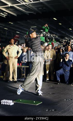 Arabian Gulf (3. März 2004) – Matrosen beobachten, wie der Profi-Golfer Tiger Woods während einer Demonstration in der Hangerbucht des Atomflugzeugträgers USS George Washington (CVN 73) einige Golfbälle schlug. Die George Washington Carrier Strike Group (CSG) und Carrier Air Wing Seven (CVW-7) sind im Arabischen Golf stationiert. Stockfoto