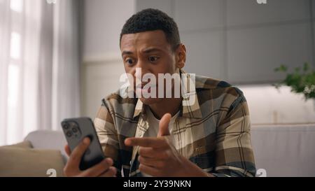 Wütender afroamerikanischer Mann birassisch verrückter männlicher ethnischer Kerl Benutzer wütend genervt irritiertes Sprechen Schreien Schreien Handy Videoanruf Chat Stockfoto