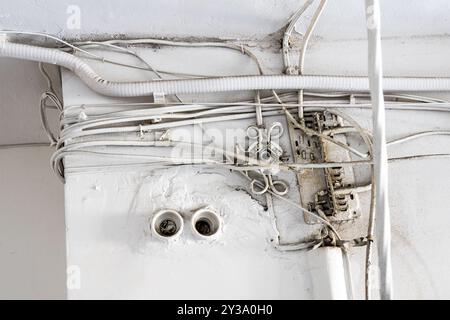 Verwickelte Elektrodrähte an der Wand in der Halle eines Wohngebäudes Stockfoto