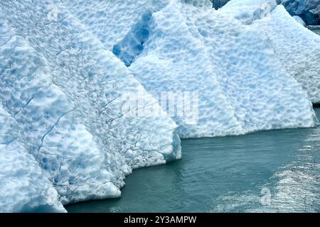 Atemberaubende Nahaufnahme der strukturierten Eisberge, die im klaren blauen Wasser schweben und die Schönheit der Natur und des kalten Klimas zeigen. Stockfoto