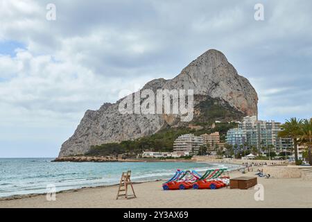 Idyllischer Calpe Beach Szenische Felsformation Sonnenanbeter Tretboote Palmen Sommerurlaub Reiseziel Costa Blanca Spanien Stockfoto